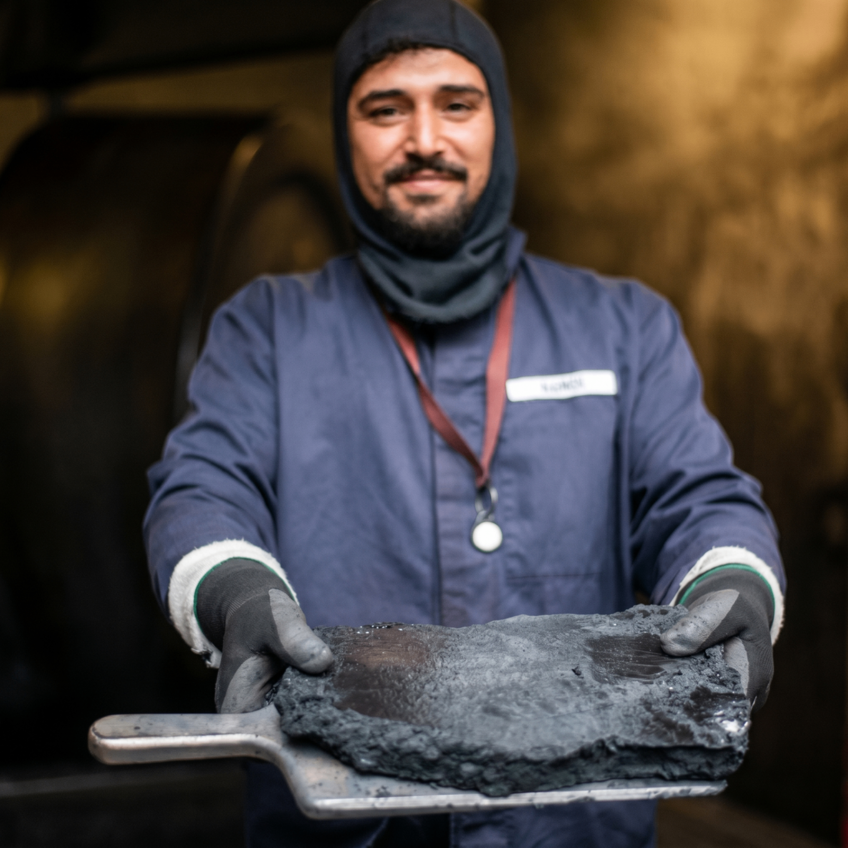 WANO powderman presenting a freshly pressed slab of black powder cake on a paddle